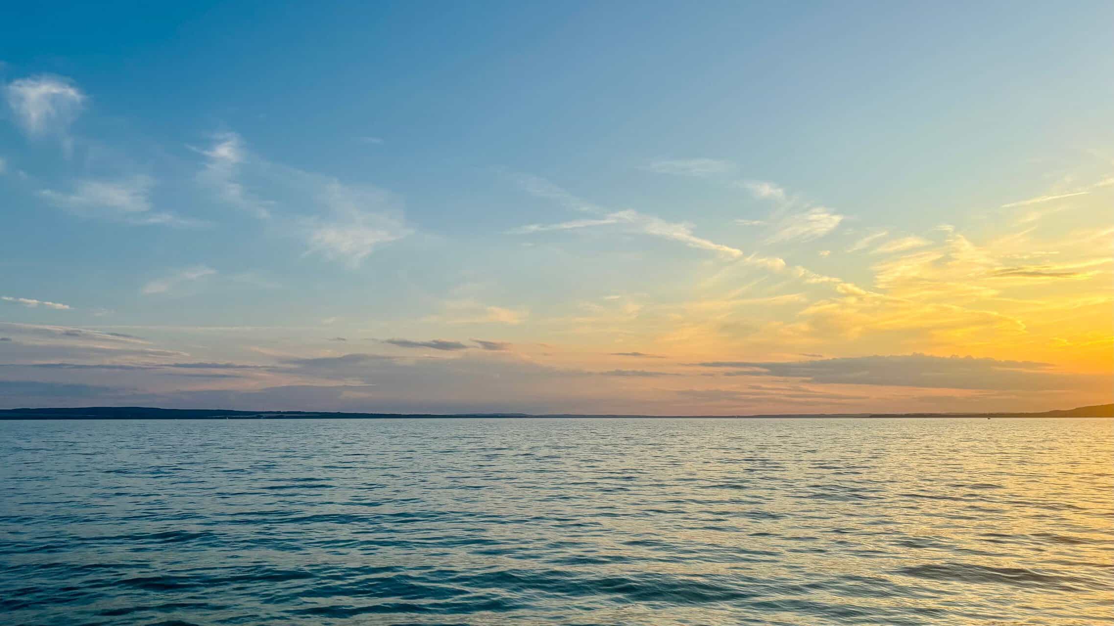 Forside Beautiful sunset over Lake Balaton in Hungary, capturing serene water and colorful skies.
