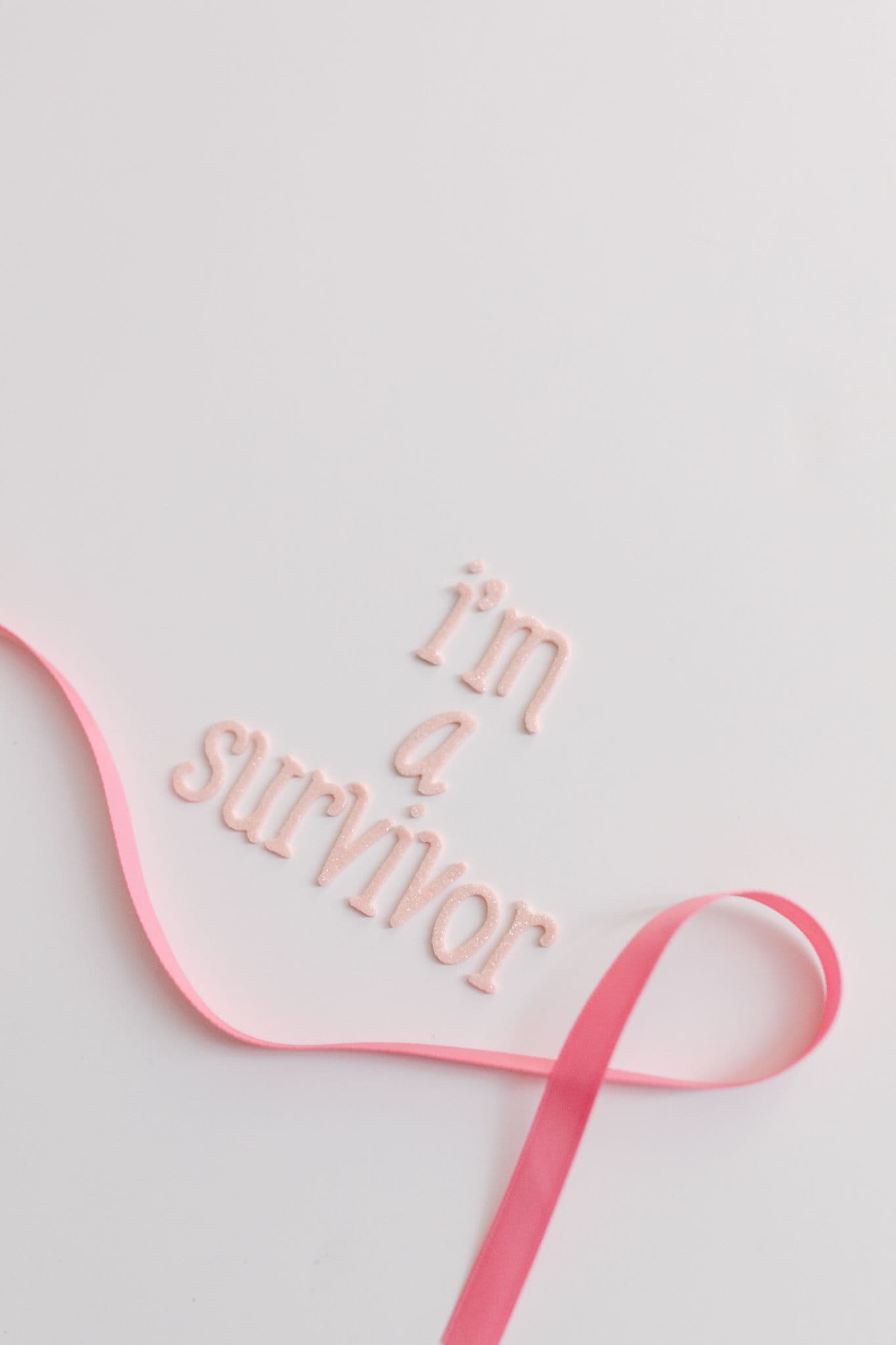 Forside Empowering cancer survivor message with pink ribbon on white background for awareness.